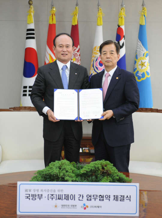 CJ주식회사 이채욱 부회장(왼쪽)과 국방부 한민구 장관이 국군 장병 복지증진을 위한 업무협약을 체결하고 협약서를 교환하고 있다. CJ그룹 제공